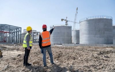 Two engineers are working at the construction site of the chemical plant under construction